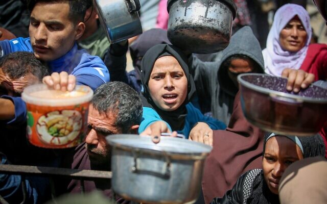 Des Palestiniens déplacés attendant de recevoir un repas, dans le nord de la bande de Gaza, le 4 mai 2025. (Crédit : Ali Hassan/Flash90) Des Palestiniens déplacés attendant de recevoir un repas, dans le nord de la bande de Gaza, le 4 mai 2025. (Crédit : Ali Hassan/Flash90)