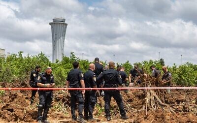 Les forces de sécurité israéliennes sur le site où un missile tiré depuis le Yémen a frappé une zone de l'aéroport Ben Gurion, le 4 mai 2025. (Crédit : Chaïm Goldberg/Flash90)