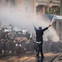 Des Juifs ultra-orthodoxes affrontant la police lors d'une manifestation contre leur enrôlement dans l'armée, à Jérusalem, le 5 mai 2025. (Crédit : Chaïm Goldberg/Flash90)