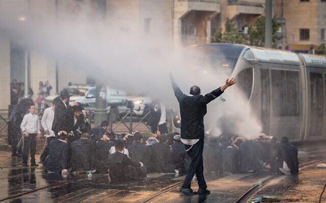 Des Juifs ultra-orthodoxes affrontant la police lors d'une manifestation contre leur enrôlement dans l'armée, à Jérusalem, le 5 mai 2025. (Crédit : Chaïm Goldberg/Flash90)
