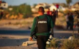 Des membres de la presse attendent le convoi de la Croix-Rouge après que la presse ait été exclue de la cérémonie de remise de l'otage israélien détenu par le Hamas, dans la rue Salah al-Din, à l'est de Deir al-Balah, dans le centre de la bande de Gaza, le 12 mai 2025. Illustration (Crédit : Ali Hassan/Flash90)