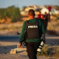 Des membres de la presse attendent le convoi de la Croix-Rouge après que la presse ait été exclue de la cérémonie de remise de l'otage israélien détenu par le Hamas, dans la rue Salah al-Din, à l'est de Deir al-Balah, dans le centre de la bande de Gaza, le 12 mai 2025. Illustration (Crédit : Ali Hassan/Flash90)