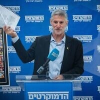 Le chef du parti Les Démocrates, Yaïr Golan, brandissant ce qu'il présente comme une plainte pour diffamation déposée par le Premier ministre Benjamin Netanyahu, lors d'une réunion de sa faction à la Knesset, à Jérusalem, le 12 mai 2025. (Crédit : Yonatan Sindel/Flash90)