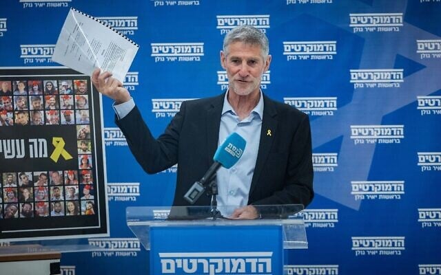 Le chef du parti Les Démocrates, Yaïr Golan, brandissant ce qu'il présente comme une plainte pour diffamation déposée par le Premier ministre Benjamin Netanyahu, lors d'une réunion de sa faction à la Knesset, à Jérusalem, le 12 mai 2025. (Crédit : Yonatan Sindel/Flash90)