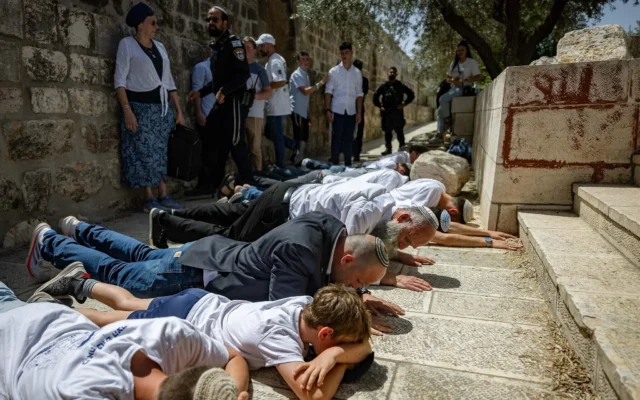 Le député Otzma Yehudit Yitzhak Kroizer (en blazer bleu) parmi plusieurs Juifs prosternés sur le mont du Temple sous le regard des policiers, lors de la Journée de Jérusalem, le 26 mai 2025. (Crédit : Yonatan Sindel/Flash90) Le député Otzma Yehudit Yitzhak Kroizer (en blazer bleu) parmi plusieurs Juifs prosternés sur le mont du Temple sous le regard des policiers, lors de la Journée de Jérusalem, le 26 mai 2025. (Crédit : Yonatan Sindel/Flash90)