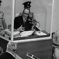 Le criminel de guerre nazi Adolf Eichmann se tient dans une cabine de protection en verre, entouré de la police israélienne, lors de son procès le 22 juin 1961 à Jérusalem. (Crédit : Bureau du Premier ministre)