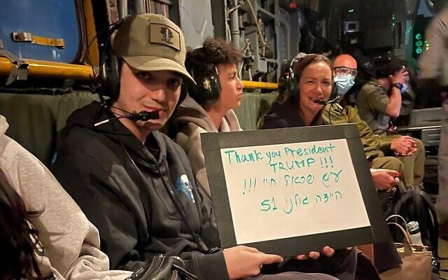Le sergent Edan Alexander tenant un panneau sur lequel il est écrit : "Merci président Trump !!! Le peuple d'Israël vit !!! Allez Golani 51", transporté par hélicoptère avec sa famille depuis la base de Reïm, dans le sud d'Israël, vers l'hôpital Sourasky de Tel Aviv, le 12 mai 2025. (Crédit : Armée israélienne)