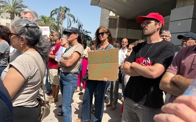 Des enseignants et des militants rassemblés pour protester contre le renvoi potentiel de l'enseignant Storm Tzemach, qui, selon eux, est puni pour avoir réclamé des salaires équitables, devant le ministère de l'Éducation à Tel Aviv, le 11 mai 2025. (Crédit : Ariela Karmel/Times of Israel)