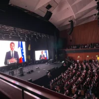 Le président français Emmanuel Macron adresse un message vidéo au Sommet populaire pour la paix, au Centre international des congrès de Jérusalem, le 9 mai 2025. (Crédit : Rossella Tercatin / Times of Israel)