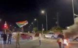 Un manifestant se tient au-dessus d'une voiture brandissant le drapeau druze lors d'une manifestation dans le nord d'Israël appelant le gouvernement à aider la communauté druze en Syrie au milieu de la violence sectaire, le 1er mai 2025. (Capture d'écran, X : Used in accordance with Clause 27a of the Copyright Law) )