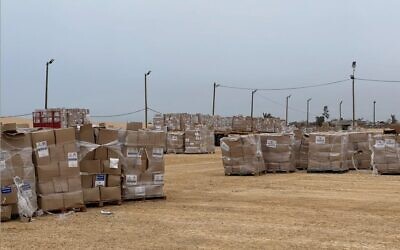 Des Palestiniens récupèrent des cartons d'aide humanitaire sur un site de distribution géré par la Fondation humanitaire de Gaza, le 26 mai 2025. (Crédit : GHF)