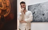 L'ex-otage Andrey Kozlov pose à New York en mai 2025 avec l'œuvre d'art qu'il a créée au cours des derniers mois. (Crédit : autorisation)