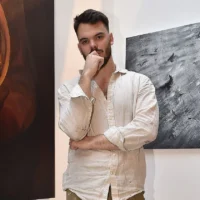 L'ex-otage Andrey Kozlov pose à New York en mai 2025 avec l'œuvre d'art qu'il a créée au cours des derniers mois. (Crédit : autorisation)