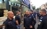 Le chef de la police de Tel Aviv, Haïm Sargrof (à gauche) et d'autres hauts responsables de la police, sur les lieux d'un vol meurtrier présumé, à Tel Aviv, le 27 mai 2025. (Crédit : Porte-parole de la police)