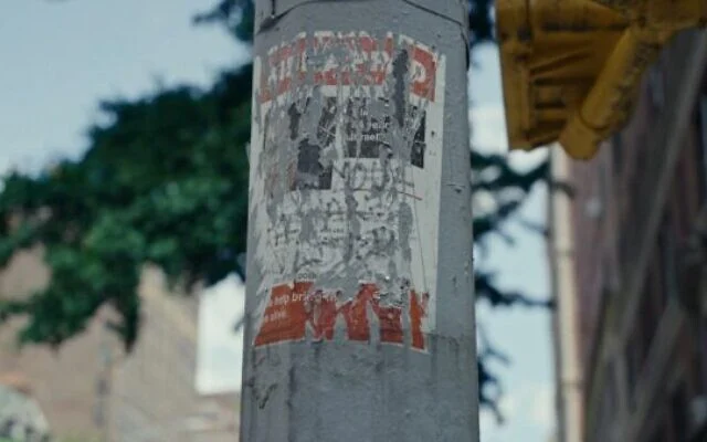 Illustration : Une affiche concernant un otage israélien de 84 ans enlevé à Gaza le 7 octobre, abîmée et déchirée, dans le film de Nim Shapira « TORN : The Israel-Palestine Poster War on NYC Streets ». (Crédit : Eyal Bau Cohen)