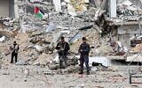 Des membres des forces de sécurité loyales au Hamas montent la garde devant un complexe de police détruit dans la ville de Gaza, le 22 janvier 2025, au quatrième jour d'un cessez-le-feu entre Israël et le Hamas. (Omar Al-Qattaa / AFP)