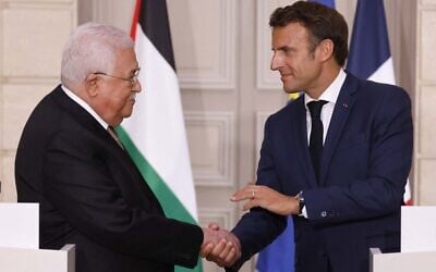Le président français Emmanuel Macron (à droite) serrant la main du dirigeant de l'Autorité palestinienne Mahmoud Abbas lors d'une conférence de presse, à l'Élysée, à Paris, le 20 juillet 2022. (Crédit : Ludovic Marin/POOL/AFP)