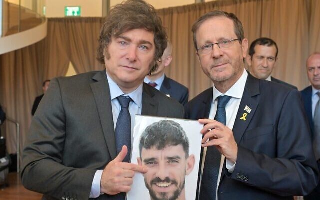 Le président Isaac Herzog (à droite) et son homologue argentin Javier Milei tenant une photo de l'otage du Hamas Ariel Cunio, lors de la cérémonie de remise du prix Genesis, à Jérusalem, le 12 juin 2025. (Crédit : Kobi Gideon/GPO)