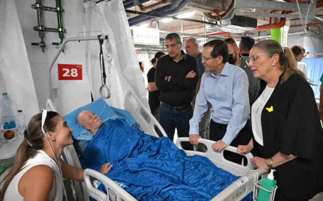 Le président Isaac Herzog rendant visite aux Israéliens blessés lors des récentes frappes de missiles iraniens dans les installations souterraines de l'hôpital Sheba, le 16 juin 2025. (Crédit : Haïm Zach/GPO)
