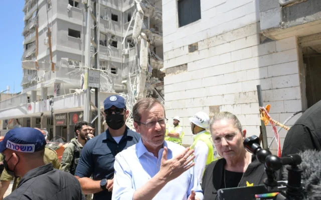 Photo d'illustration : Le président Isaac Herzog visite les lieux d'une frappe de missile iranien meurtrière dans la ville de Bat Yam, le 15 juin 2025 (Crédit : Amos Ben Gershom/GPO)