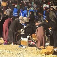 Des employés palestiniens locaux de la Gaza Humanitarian Foundation, vêtus de gilets bleus, formant une chaîne humaine pour protéger les femmes bénéficiaires de l'aide humanitaire sur l'un des sites de distribution de la GHF, le 9 juin 2025. (Crédit : GHF)