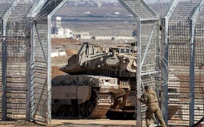 Le 2 mars 2025, un soldat de l'armée israélienne ferme la porte derrière un char de combat Merkava qui a franchi la clôture de barbelés pour entrer dans la zone tampon surveillée par l'ONU pour séparer les forces israéliennes et syriennes sur le plateau du Golan, près du point de contrôle de l'ONU à Quneitra. (Photo de Jalaa MAREY / AFP)