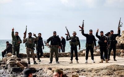 Illustration : Des membres des forces de sécurité fidèles au gouvernement intérimaire syrien posant avec leurs armes à feu sur la côte méditerranéenne, dans la ville occidentale de Lattaquié, en Syrie, le 9 mars 2025. (Crédit : Omar Haj Kadour/AFP)