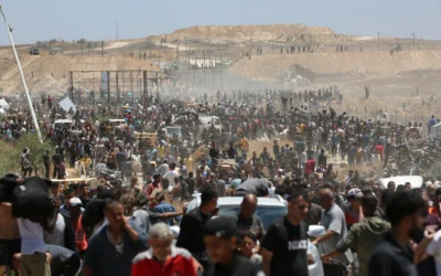 Des Palestiniens déplacés transportant des vivres reviennent d’un centre de distribution dans le centre de la bande de Gaza, le 29 mai 2025. (Crédit : Eyad BABA / AFP)
