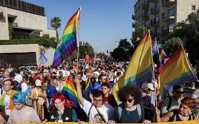 Des participants défilent avec un drapeau de fierté géant lors de la parade annuelle de la fierté de Jérusalem dans le centre de la ville, le 5 juin 2025. (Crédit : AHMAD GHARABLI / AFP)