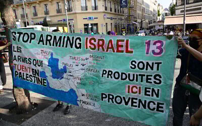 Des manifestants installent une banderole "Les armes qui tuent en Palestine sont produites ici en Provence" lors d'un rassemblement contre une cargaison de pièces d'équipement militaire Eurolinks destinées à Israël, à Marseille le 5 juin 2025. (Crédit : Christophe SIMON / AFP)