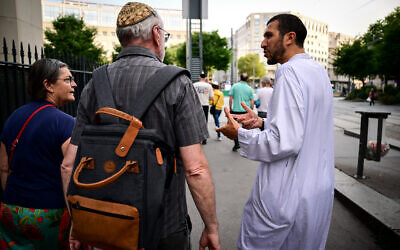 Le secrétaire de la mosquée Errahma, Nabil Bouslama (à droite), s'entretient avec des participants lors d'une marche interconfessionnelle organisée par les responsables de la mosquée Errahma, de la synagogue et de l'église de Villeurbanne, dans l'est de la France, le 9 juin 2025. (Crédit : OLIVIER CHASSIGNOLE / AFP)
