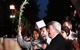 Le fondateur du parti français de gauche radicale La France Insoumise (LFI), Jean-Luc Mélenchon (à droite), s'exprimant aux côtés de l'eurodéputée du parti LFI, Rima Hassan (à gauche), tenant un rameau d'olivier, lors d'un rassemblement en soutien à Rima sur la place de la République à Paris, le 12 juin 2025. (Crédit : Thibaud Moritz/AFP)