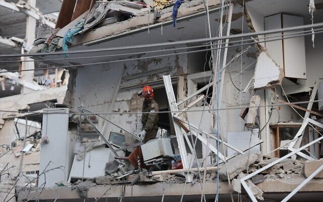 Un secouriste travaillant dans un bâtiment endommagé à la suite d'une frappe de missile iranien, dans la ville de Bat Yam, au sud de Tel Aviv, tôt le 15 juin 2025. (Crédit : Jack Guez/AFP) Un secouriste travaillant dans un bâtiment endommagé à la suite d'une frappe de missile iranien, dans la ville de Bat Yam, au sud de Tel Aviv, tôt le 15 juin 2025. (Crédit : Jack Guez/AFP)