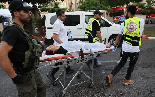 Les secours transportant une personne sur une civière après une frappe d'un missile iranien, dans la ville de Bat Yam, au sud de Tel Aviv, tôt le 15 juin 2025. (Crédit : Jack Guez/AFP) Les secours transportant une personne sur une civière après une frappe d'un missile iranien, dans la ville de Bat Yam, au sud de Tel Aviv, tôt le 15 juin 2025. (Crédit : Jack Guez/AFP)