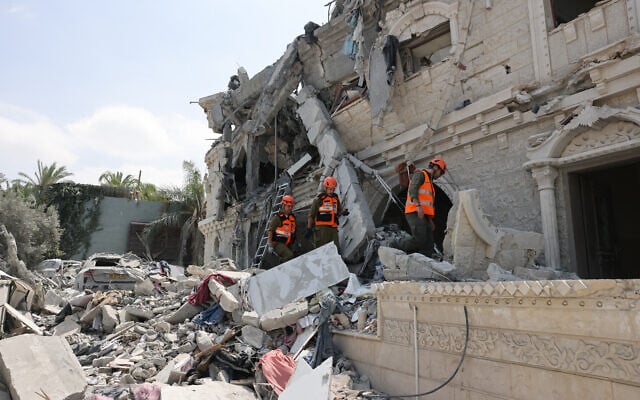 Les membres de l'équipe de recherche et de sauvetage inspectent les décombres d'un bâtiment endommagé dans la ville de Tamra, dans le nord d'Israël, à la suite d'une attaque à la roquette lancée par l'Iran dans la nuit du 15 juin 2025, qui a fait quatre morts (Crédit : AHMAD GHARABLI / AFP)