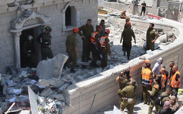 Des membres de l'équipe de recherche et de sauvetage inspectent les décombres d'un bâtiment dans la ville de Tamra, dans le nord d'Israël, à la suite d'une attaque de missiles lancée depuis l'Iran au cours de la nuit le 15 juin 2025, tuant quatre personnes dont un enfant. (Photo par Ahmad GHARABLI/AFP) Des membres de l'équipe de recherche et de sauvetage inspectent les décombres d'un bâtiment dans la ville de Tamra, dans le nord d'Israël, à la suite d'une attaque de missiles lancée depuis l'Iran au cours de la nuit le 15 juin 2025, tuant quatre personnes dont un enfant. (Photo par Ahmad GHARABLI/AFP)