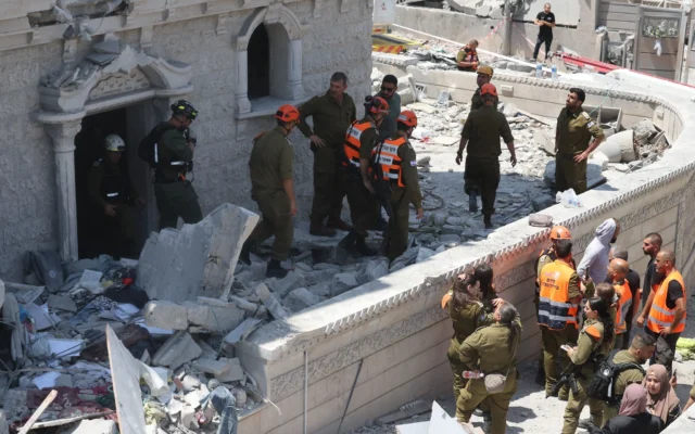 Des membres de l'équipe de recherche et de sauvetage inspectent les décombres d'un bâtiment endommagé dans la ville de Tamra, dans le nord d'Israël, le 15 juin 2025. (Crédit : Ahmad GHARABLI / AFP) Des membres de l'équipe de recherche et de sauvetage inspectent les décombres d'un bâtiment endommagé dans la ville de Tamra, dans le nord d'Israël, le 15 juin 2025. (Crédit : Ahmad GHARABLI / AFP)