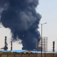 Un épais panache de fumée et de feu s'élève dans le ciel au-dessus d'une raffinerie de pétrole du sud de Téhéran, bombardée par Israël pendant la nuit, le 15 juin 2025. (Photo de ATTA KENARE / AFP)