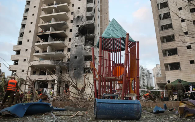 Les secours à côté d'un bâtiment endommagé à la suite d'une frappe d'un missile iranien dans la ville israélienne de Petah Tikva, à l'est de Tel Aviv, le 16 juin 2025 (Crédit : Jack Guez/AFP) Les secours à côté d'un bâtiment endommagé à la suite d'une frappe d'un missile iranien dans la ville israélienne de Petah Tikva, à l'est de Tel Aviv, le 16 juin 2025 (Crédit : Jack Guez/AFP)