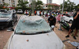 Un homme inspectant une voiture endommagée après un tir de missile iranien dans la ville israélienne de Petah Tikva, à l'est de Tel Aviv, le 16 juin 2025. (Crédit : Jack Guez/AFP)