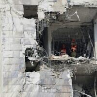 Des secouristes inspectent un bâtiment endommagé par un missile iranien à Petah Tikva, le 16 juin 2025. (Crédit : Jack GUEZ / AFP)