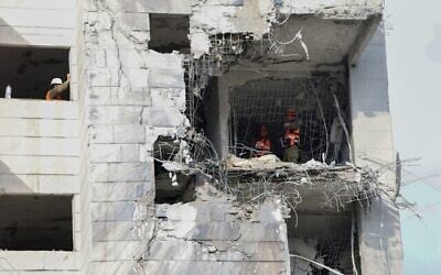 Des secouristes inspectent un bâtiment endommagé par un missile iranien à Petah Tikva, le 16 juin 2025. (Crédit : Jack GUEZ / AFP)