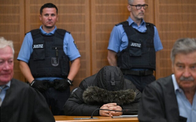 Le médecin syrien Alaa Moussa (au centre), condamné à la prison à perpétuité pour crimes contre l'humanité sous le régime de l'ancien dictateur syrien Bashar el-Assad,  au tribunal régional supérieur de Francfort, à Francfort-sur-le-Main, dans l'ouest de l'Allemagne, le 16 juin 2025. (Crédit :  Kirill Kudryavtsev /AFP)