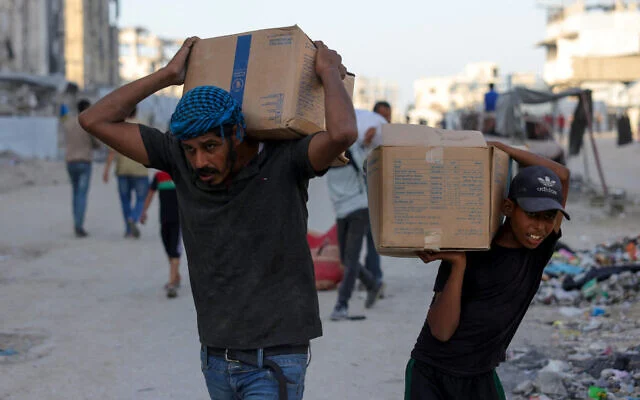 Des Palestiniens transportent des colis d’aide humanitaire à l’ouest de Jabalia, dans le nord de la bande de Gaza, le 16 juin 2025, après que des camions chargés d’aide auraient pénétré dans le nord de Gaza par la porte Zikim contrôlée par Israël. (Bachar TALEB / AFP) Des Palestiniens transportent des colis d’aide humanitaire à l’ouest de Jabalia, dans le nord de la bande de Gaza, le 16 juin 2025, après que des camions chargés d’aide auraient pénétré dans le nord de Gaza par la porte Zikim contrôlée par Israël. (Bachar TALEB / AFP)