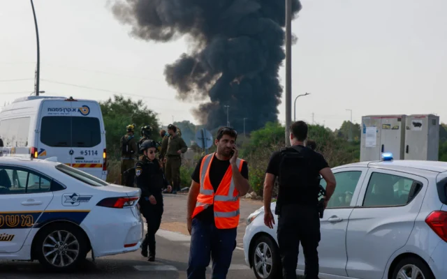 Les services d'urgence et la police israéliens se déploient sur une route fermée alors que de la fumée s'élève d'un site près de Tel-Aviv à la suite d'une salve de roquettes iraniennes le 17 juin 2025. (Crédit : Menahem KAHANA / AFP) Les services d'urgence et la police israéliens se déploient sur une route fermée alors que de la fumée s'élève d'un site près de Tel-Aviv à la suite d'une salve de roquettes iraniennes le 17 juin 2025. (Crédit : Menahem KAHANA / AFP)