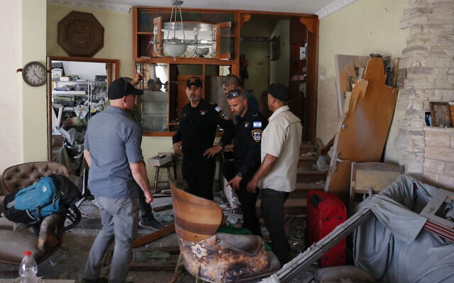 Des policiers israéliens inspectent un appartement endommagé près du site où un missile iranien a détruit quelques jours plus tôt un immeuble de trois étages dans la ville arabe-israélienne de Tamra, dans le nord du pays, tuant quatre femmes, selon les sauveteurs et les médecins, le 17 juin 2025. (Crédit : AHMAD GHARABLI / AFP)