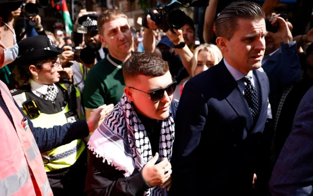 Le membre du groupe de rap irlandais Kneecap, Liam O'Hanna, qui se produit sous le nom de scène Mo Chara, arrive au tribunal de première instance de Westminster à Londres, le 18 juin 2025 (Crédit : BENJAMIN CREMEL / AFP).