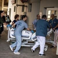 Des médecins mettent un patient en sécurité après qu'un bâtiment de l'hôpital de Soroka a été frappé par un missile iranien à Beer Sheva, dans le sud d'Israël, le 19 juin 2025. (JEAN WESSELS/AFP)