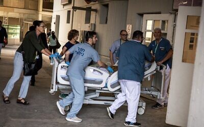 Des médecins mettent un patient en sécurité après qu'un bâtiment de l'hôpital de Soroka a été frappé par un missile iranien à Beer Sheva, dans le sud d'Israël, le 19 juin 2025. (JEAN WESSELS/AFP)