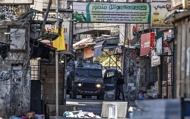 Un soldat israélien pointant son arme lors d'un raid militaire, dans le camp de réfugiés de Balata, à l'est de Naplouse, en Cisjordanie, le 19 juin 2025. (Crédit : Zain Jaafar/AFP)